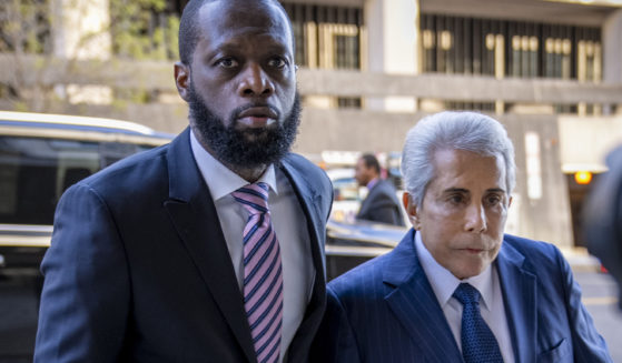 Rapper Prakazrel "Pras" Michael, left, walks into a federal court with his attorney, David Kenner, on March 30, in Washington, D.C.