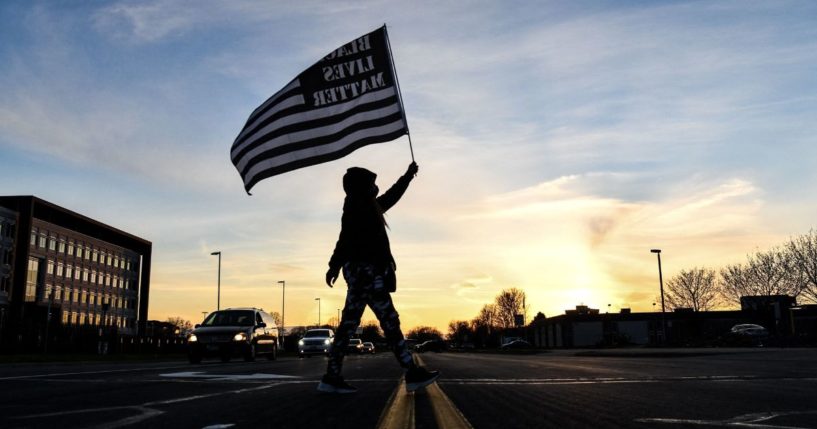 A demonstrator marches holding a Black Lives Matter flag in Brooklyn Center, Minnesota, on April 16, 2021.
