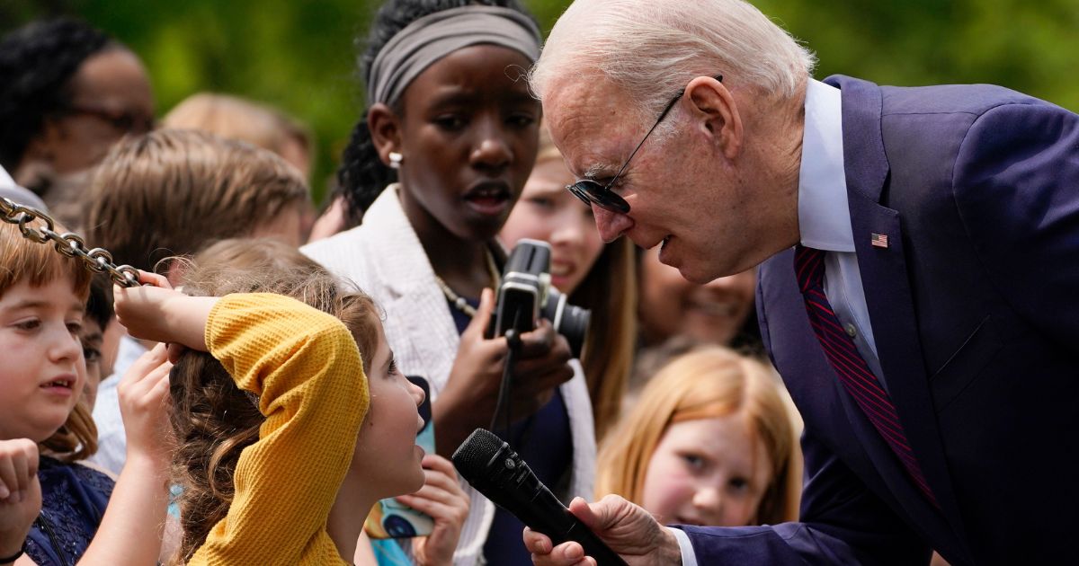 President Joe Biden listens as a little girl speaks to him during a Take Your Child to Work Day event at the White House in Washington on Thursday.
