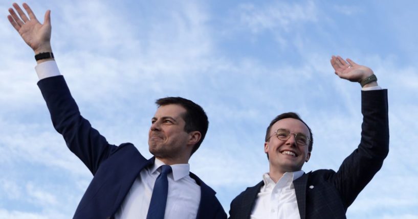 Then-Democratic presidential candidate Pete Buttigieg, left, and his "husband" Chasten Buttigieg, right, wave during a campaign town hall event in Arlington, Virginia, on Feb. 23, 2020.