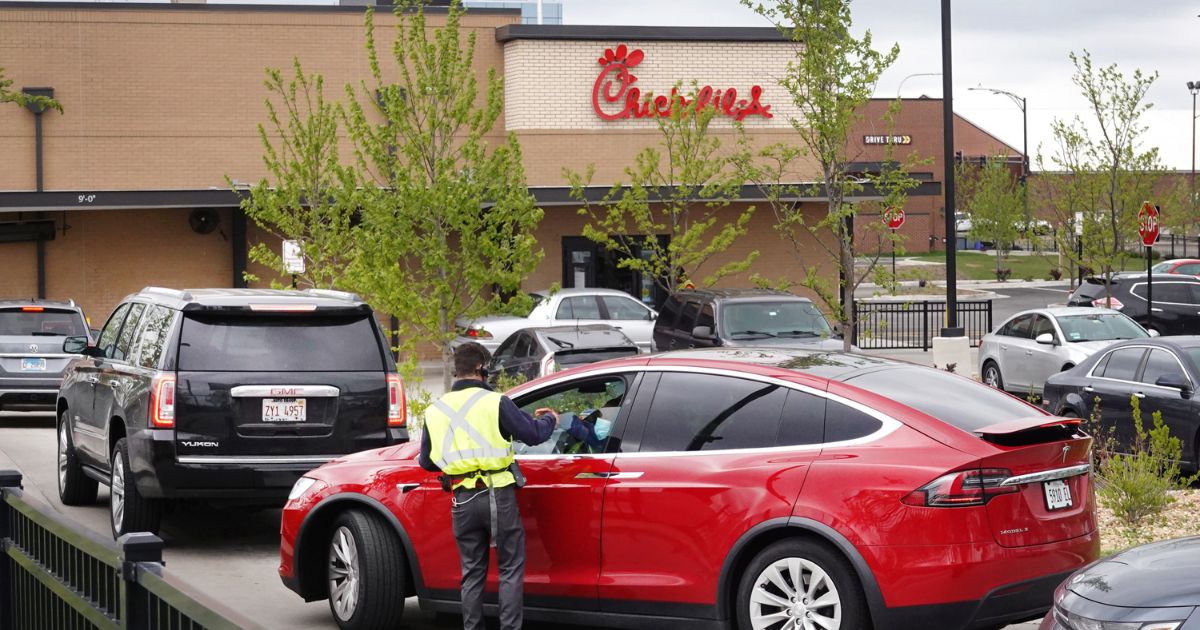 A worker takes orders from customers at a Chick-fil-A drive-thru lane in Chicago, Illinois, on May 6, 2021.