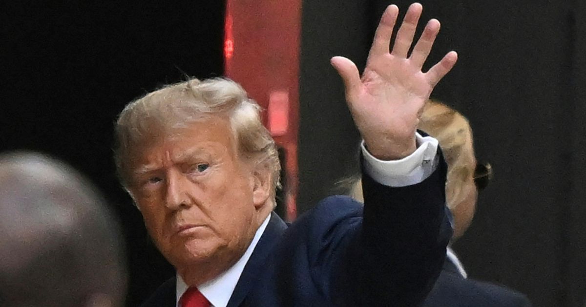 Former President Donald Trump waves as he enters Trump Tower in New York City on Monday.