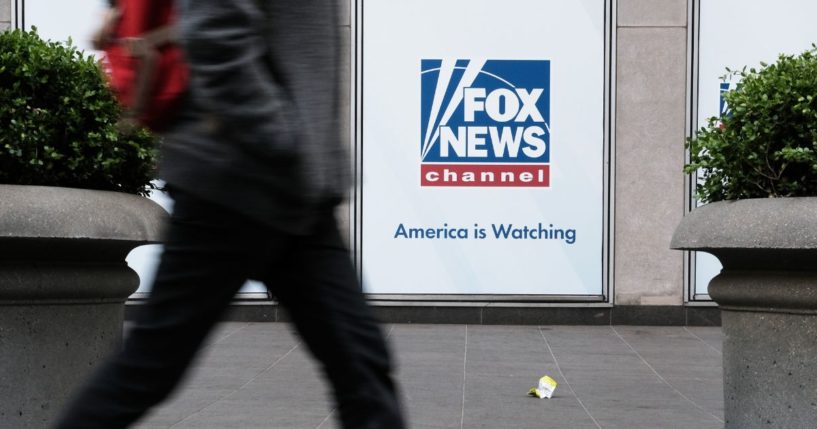 People walk by the Fox News headquarters on Tuesday in New York City.