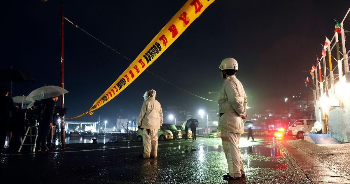 Police officers stand by a yellow rope restricting entry into the site where a man threw an explosive just before Japanese Prime Minister Fumio Kishida was to make a speech on Saturday in Wakayama, Japan.