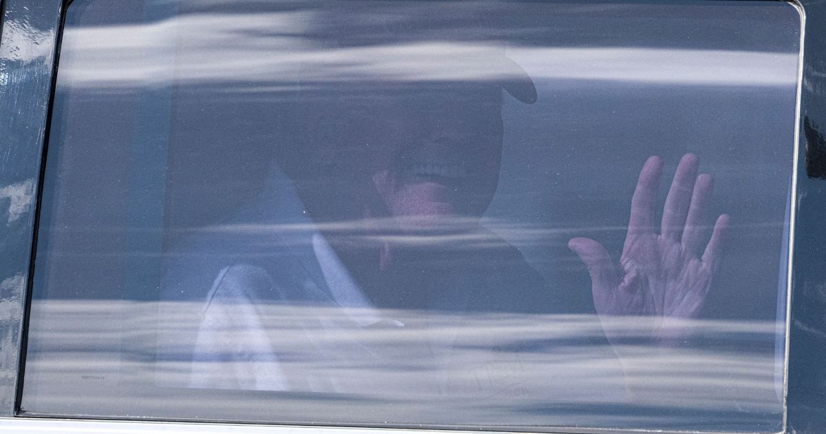 Former President Donald Trump waves from the back of his limousine on Saturday as he departs Trump International Golf Club in West Palm Beach, Florida.