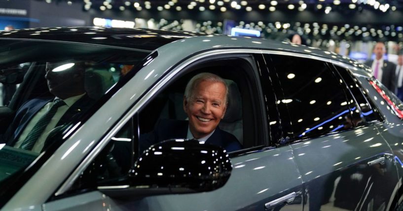 Joe Biden driving a Cadillac Lyriq through the showroom