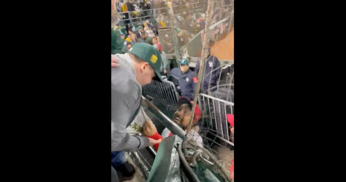 Los Angeles Angels third baseman Anthony Rendon grabs a piece of a fan's clothing Thursday in Oakland, California, in a video that has gone viral. Rendon later took a swipe at the fan.