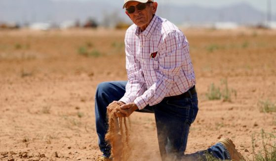 Kelly Anderson shows how dry one of his fields in Arizona