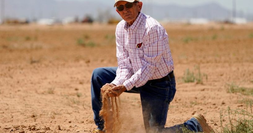 Kelly Anderson shows how dry one of his fields in Arizona
