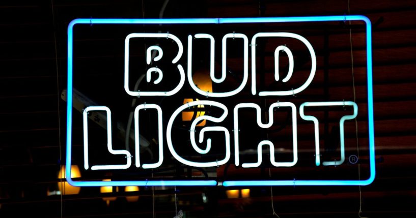 A Bud Light neon sign hangs in the window of a store in New York, New York.