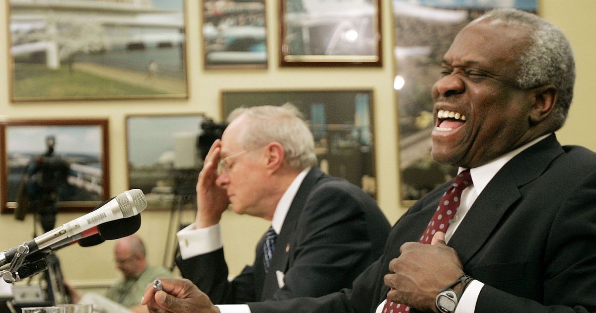 Supreme Court Justice Clarence Thomas (R) laughs as fellow Supreme Court Justice Anthony Kennedy (L) finishes telling a joke during an appearance before a subcommittee of the House Appropriations Committee April 12, 2005 on Capitol Hill in Washington, DC.