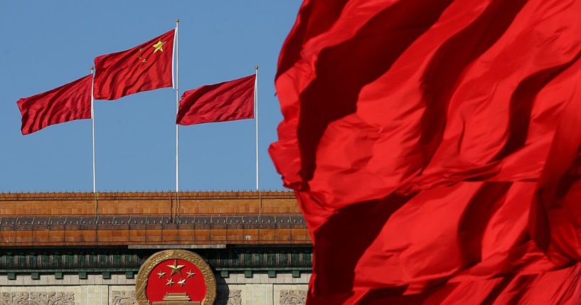 Red flags flutter in the wind near the Chinese national emblem outside the Great Hall of the People where sessions of the Chinese People's Political Consultative Conference and National People's Congress are being held on March 4, 2014, in Beijing, China.