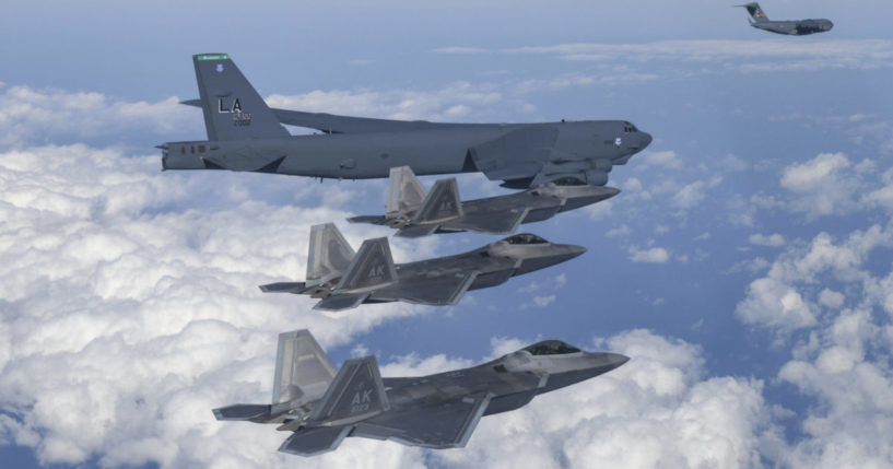 a U.S. B-52 bomber, C-17, and U.S. Air Force F-22 fighter jets flying over the Korean Peninsula