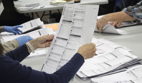 an election worker examining a ballot