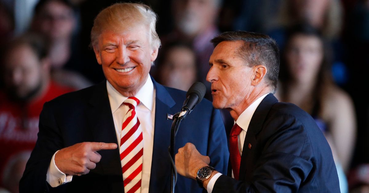 Then Republican presidential candidate Donald Trump, left, jokes with retired Gen. Michael Flynn as they speak at a rally at Grand Junction Regional Airport on Oct. 18, 2016, in Grand Junction Colorado.