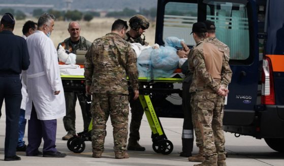 A Greek citizen rescued from Sudan is put in an ambulance at the Greek military airport in Elefsina, Greece, on Monday.