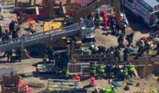 Firefighters work at the scene of an accident Monday at John F. Kennedy International Airport that killed two.