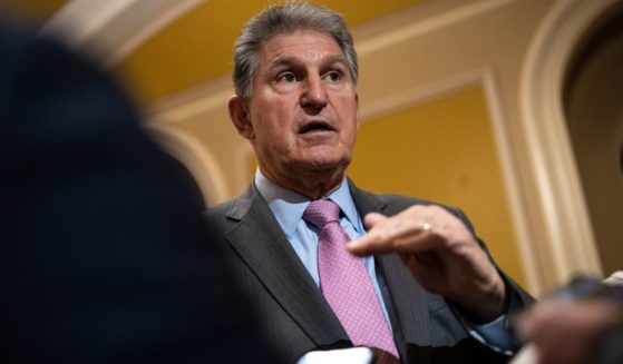 Sen. Joe Manchin (D-WV) speaks with reporters on his way to a closed-door lunch meeting with Senate Democrats at the U.S. Capitol March 22 in Washington, D.C.