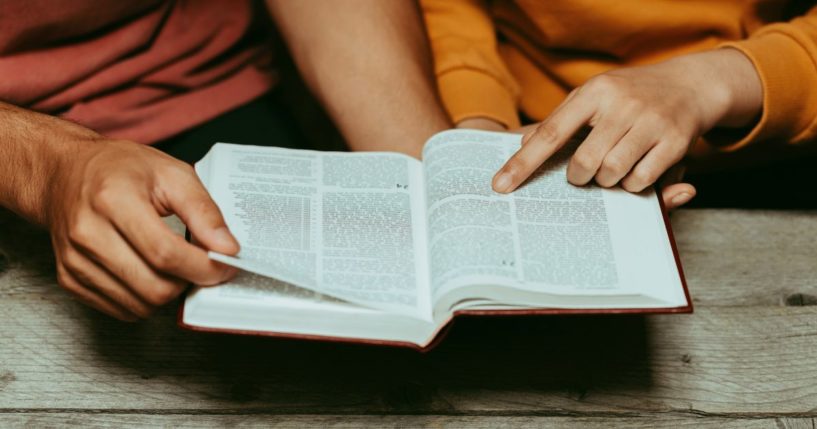 People read the Bible in this stock image.