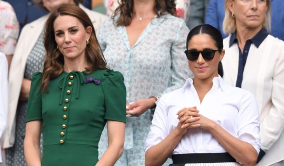 Catherine, Princess of Wales, and Meghan, Duchess of Sussex, stand together in the Royal Box on Centre Court during the Wimbledon Tennis Championships at All England Lawn Tennis and Croquet Club in London on July 13, 2019.