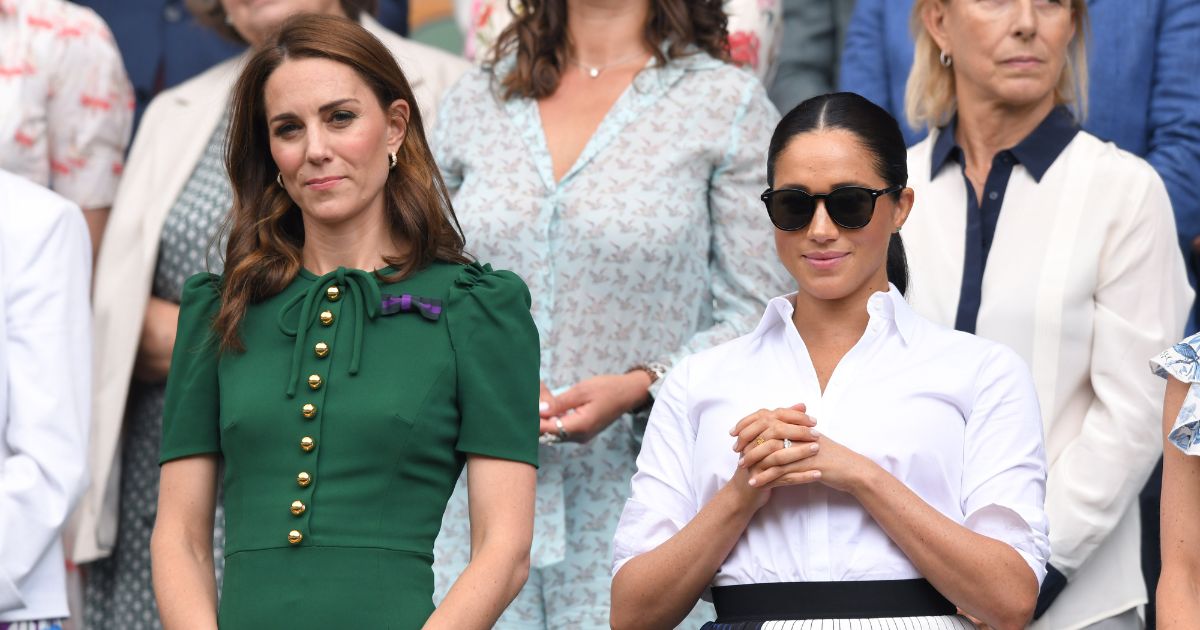 Catherine, Princess of Wales, and Meghan, Duchess of Sussex, stand together in the Royal Box on Centre Court during the Wimbledon Tennis Championships at All England Lawn Tennis and Croquet Club in London on July 13, 2019.