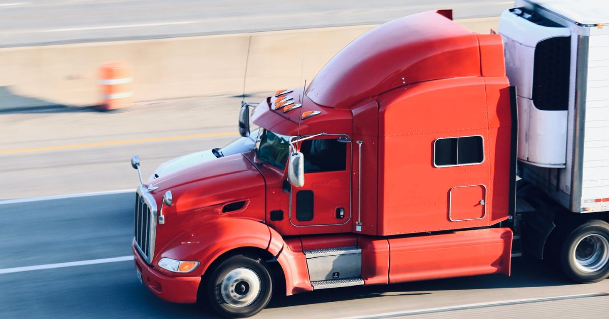 A semi truck drives on the highway in this stock image.