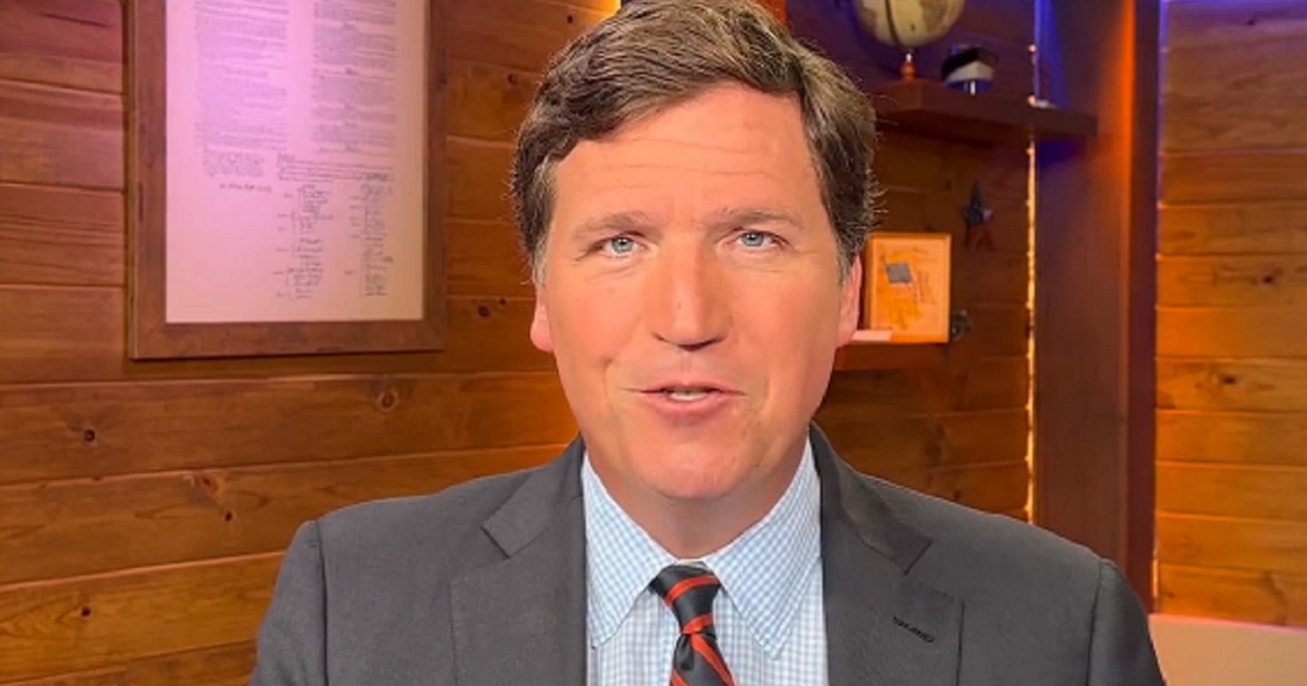 Former Fox News host Tucker Carlson grins near the end of a video he released on Twitter Wednesday night.