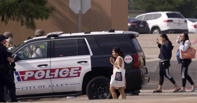 Police officers on the scene gather customers and bystanders at a shooting at a mall Saturday in Allen, Texas.