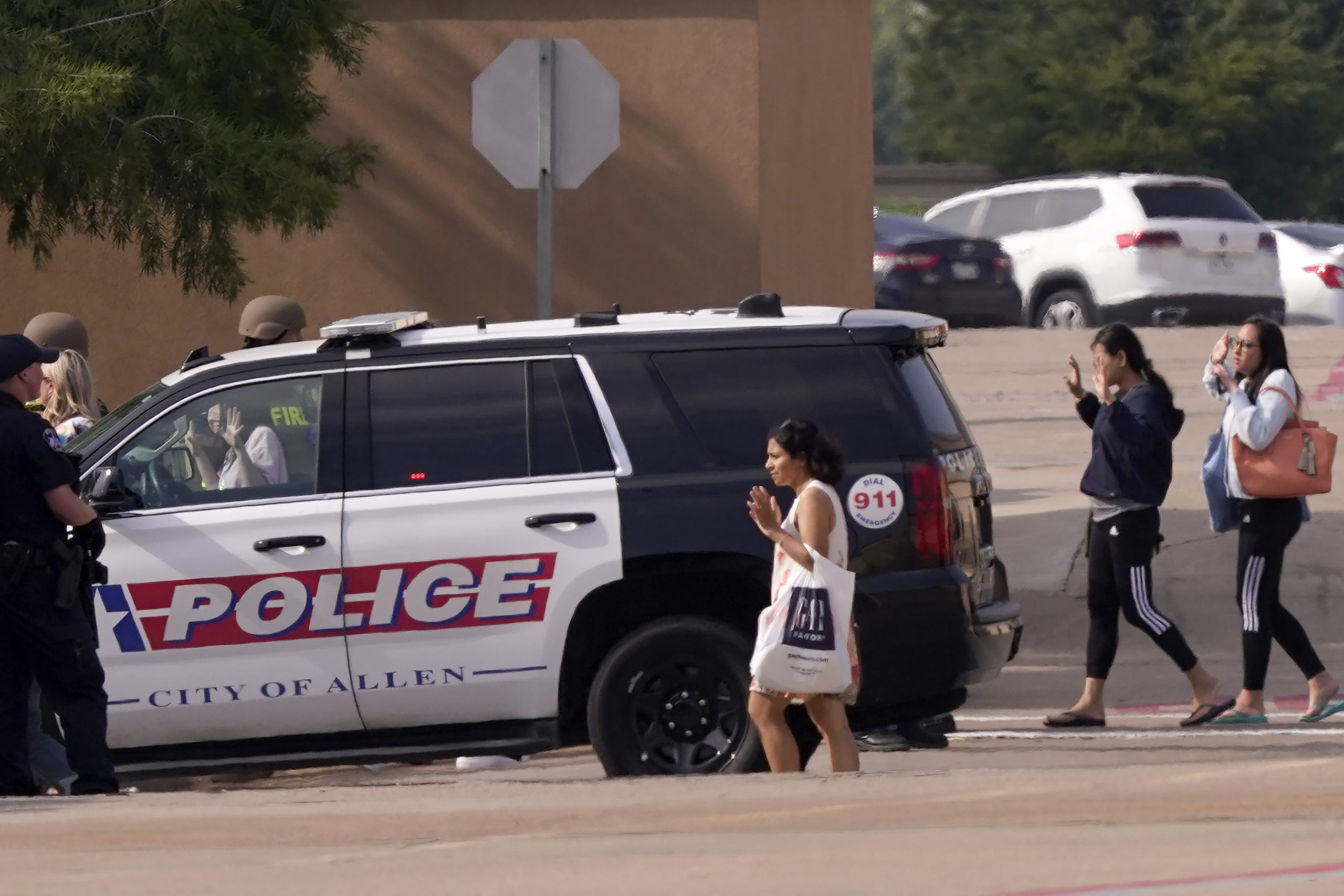 Police officers on the scene gather customers and bystanders at a shooting at a mall Saturday in Allen, Texas.