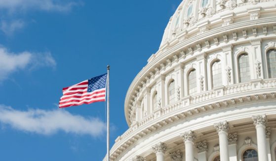 The American flag flies outside the U.S. Capitol in this stock image.