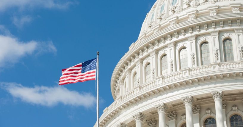 The American flag flies outside the U.S. Capitol in this stock image.