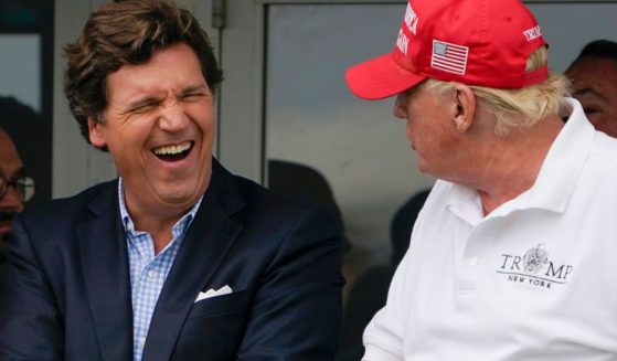 Tucker Carlson, left, and former President Donald Trump react during the final round of the Bedminster Invitational LIV Golf tournament in Bedminster, New Jersey, on July 31, 2022.