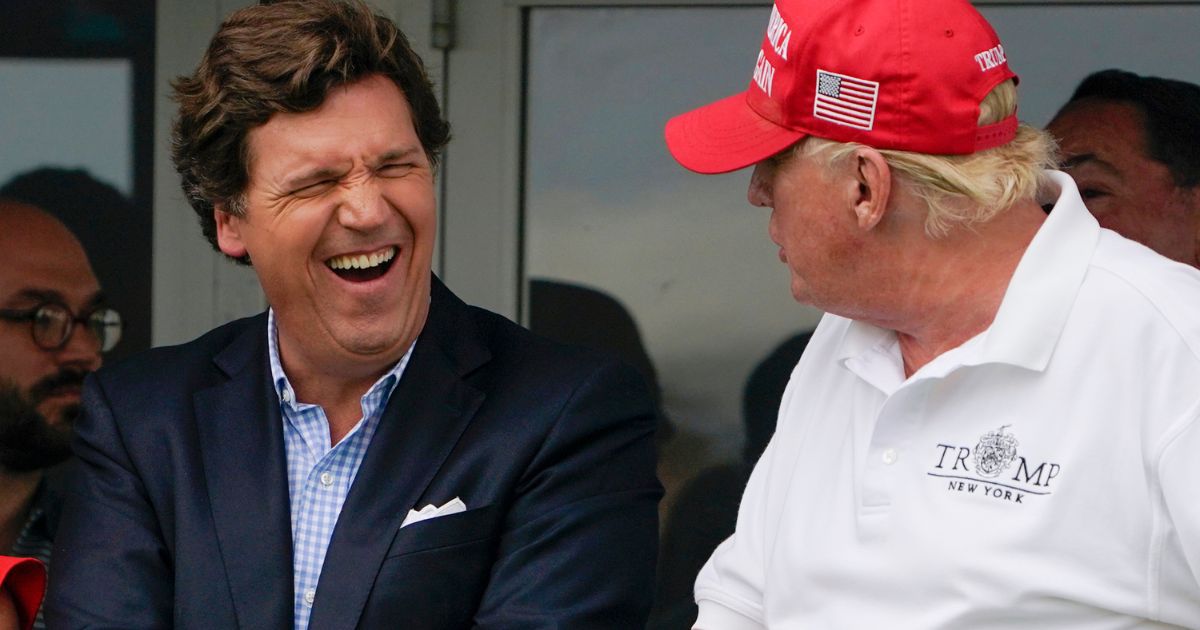 Tucker Carlson, left, and former President Donald Trump react during the final round of the Bedminster Invitational LIV Golf tournament in Bedminster, New Jersey, on July 31, 2022.