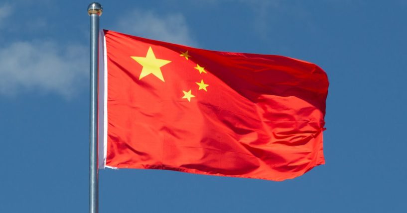 The flag of China waves from a flagpole.