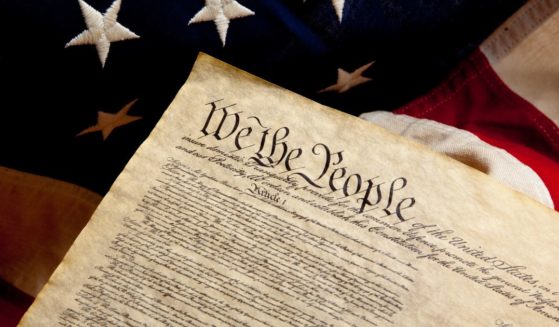 The Constitution rests on an American flag in this stock image.