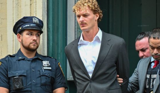 Daniel Penny is escorted in handcuffs after turning himself in to police on Friday in New York City.