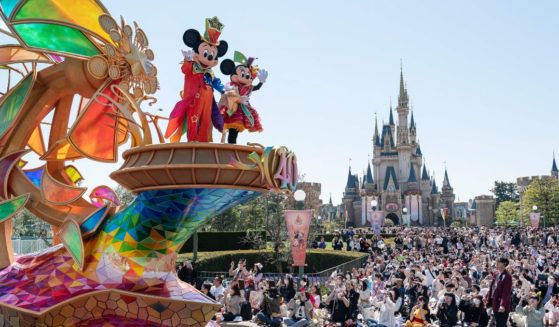 Disney characters Mickey and Minnie Mouse wave during a parade to mark the 40th anniversary of Tokyo Disneyland in Urayasu, Japan, on April 10.