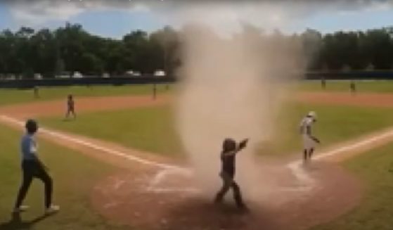 The whirlwind engulfed the 7-year-old catcher at home plate.