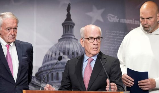 Democrat Sens. John Fetterman of Pennsylvania, right, and Edward Markey o Massachusetts, left, listen as Peter Welch of Vermont speaks during a news conference Thursday on Capitol Hill in Washington.