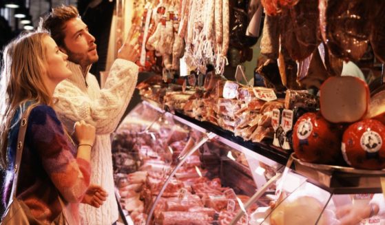 This stock photo shows a couple shopping at a meat market.