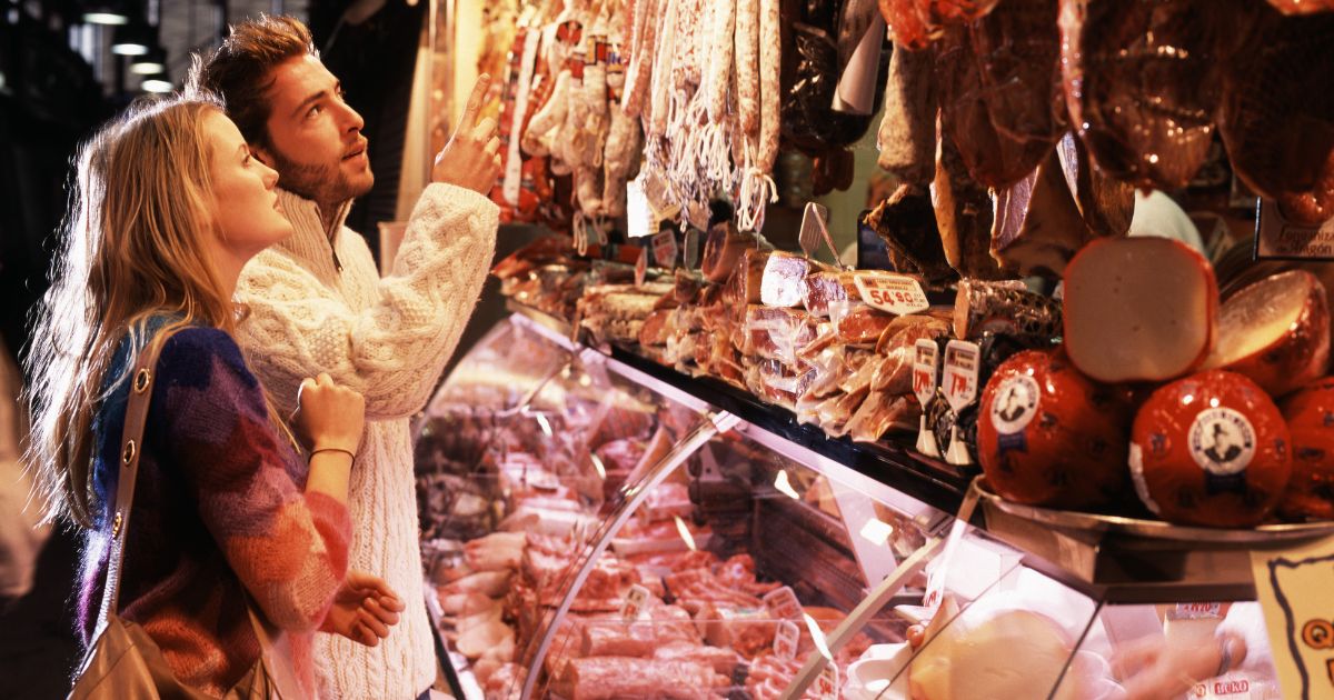 This stock photo shows a couple shopping at a meat market.