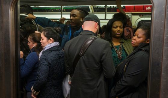 Commuters ride on a crowded downtown subway in New York City on Oct. 16, 2018.