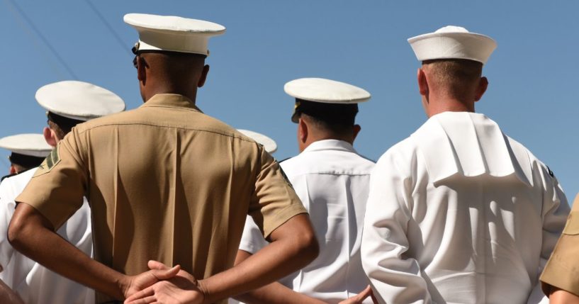 Sailors stand at attention in the above stock image.