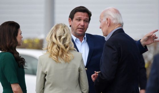 Florida Governor Ron DeSantis (2nd R), his wife Casey (L), US President Joe Biden (R) and First Lady Jill Biden (C) chat during a visit to impacted areas by Hurricane Ian at Fishermans Pass in Fort Myers, Florida, on October 5, 2022.