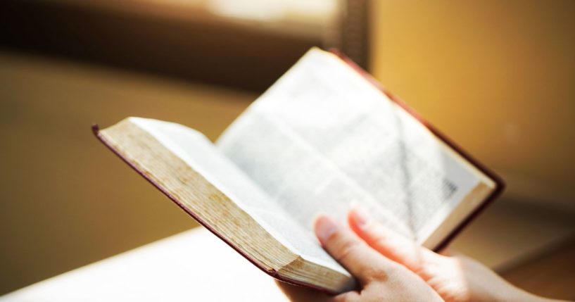 A woman reads the Bible in this stock image.