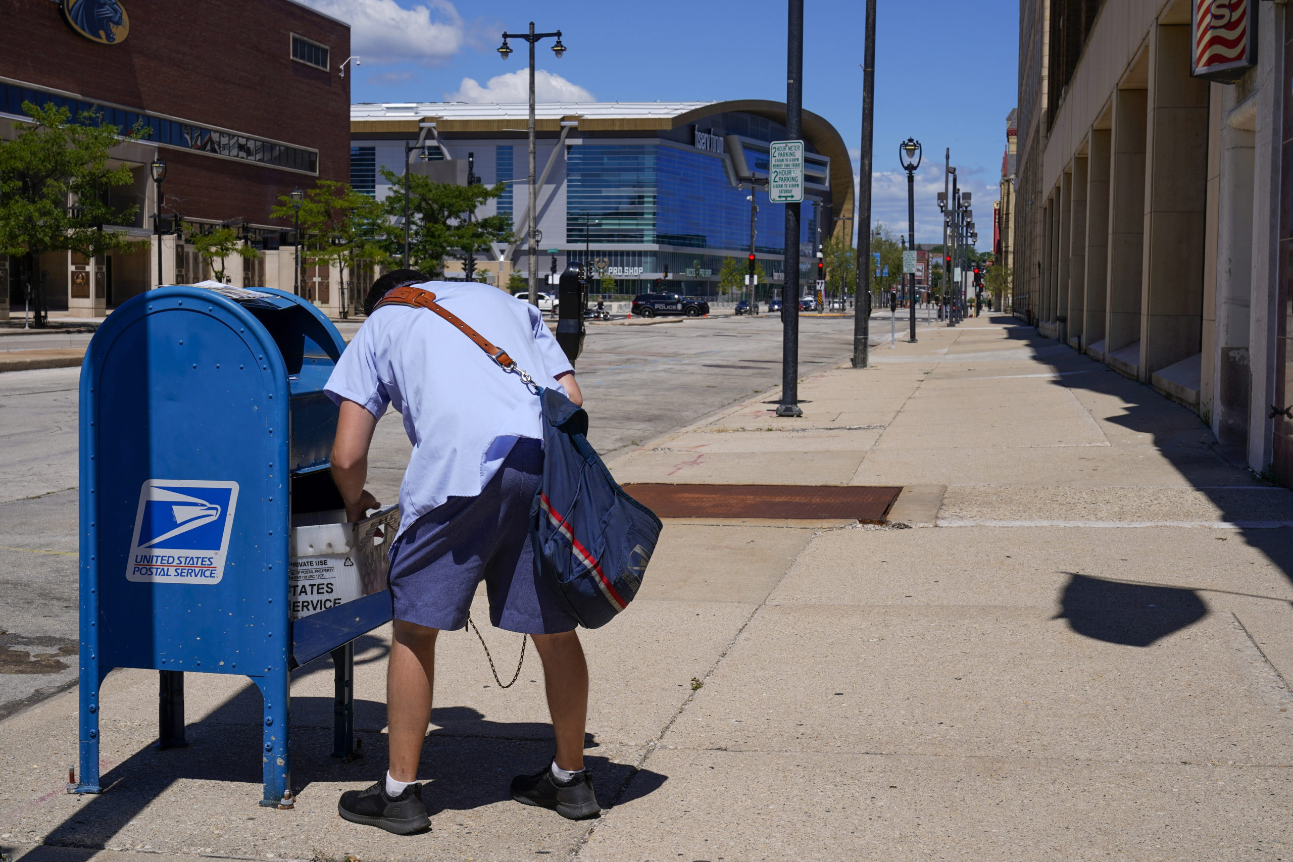 A postal worker emptying a mailbox