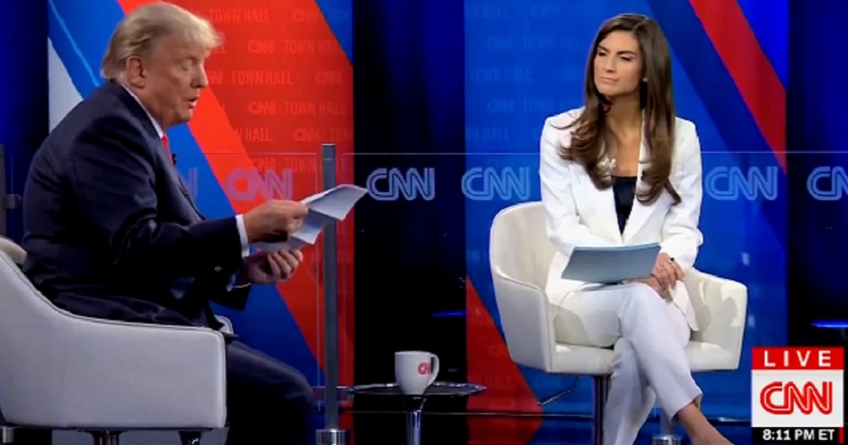 Former President Donald Trump reads printouts of his own tweets during a town hall May 10 with CNN's Kaitlan Collins.
