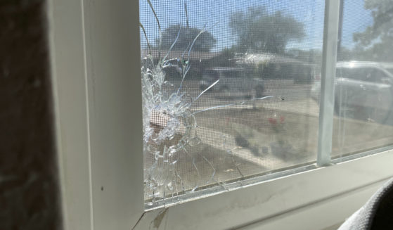 A bullet hole is seen through the bedroom window of Jolene Robledo's home Tuesday in Farmington, N.M. It was among the damage resulting from a deadly shooting along a residential street in the northwestern New Mexico community.
