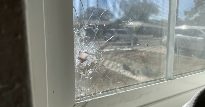 A bullet hole is seen through the bedroom window of Jolene Robledo's home Tuesday in Farmington, N.M. It was among the damage resulting from a deadly shooting along a residential street in the northwestern New Mexico community.