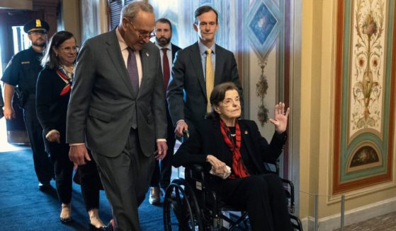 Democratic Senate Majority Leader Chuck Schumer escorts Sen. Dianne Feinstein as she arrives at the U.S. Capitol following a long absence due to health issues on May 10 in Washington, D.C.
